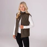 Woman wearing a brown fleece gilet over a white shirt on a plain background